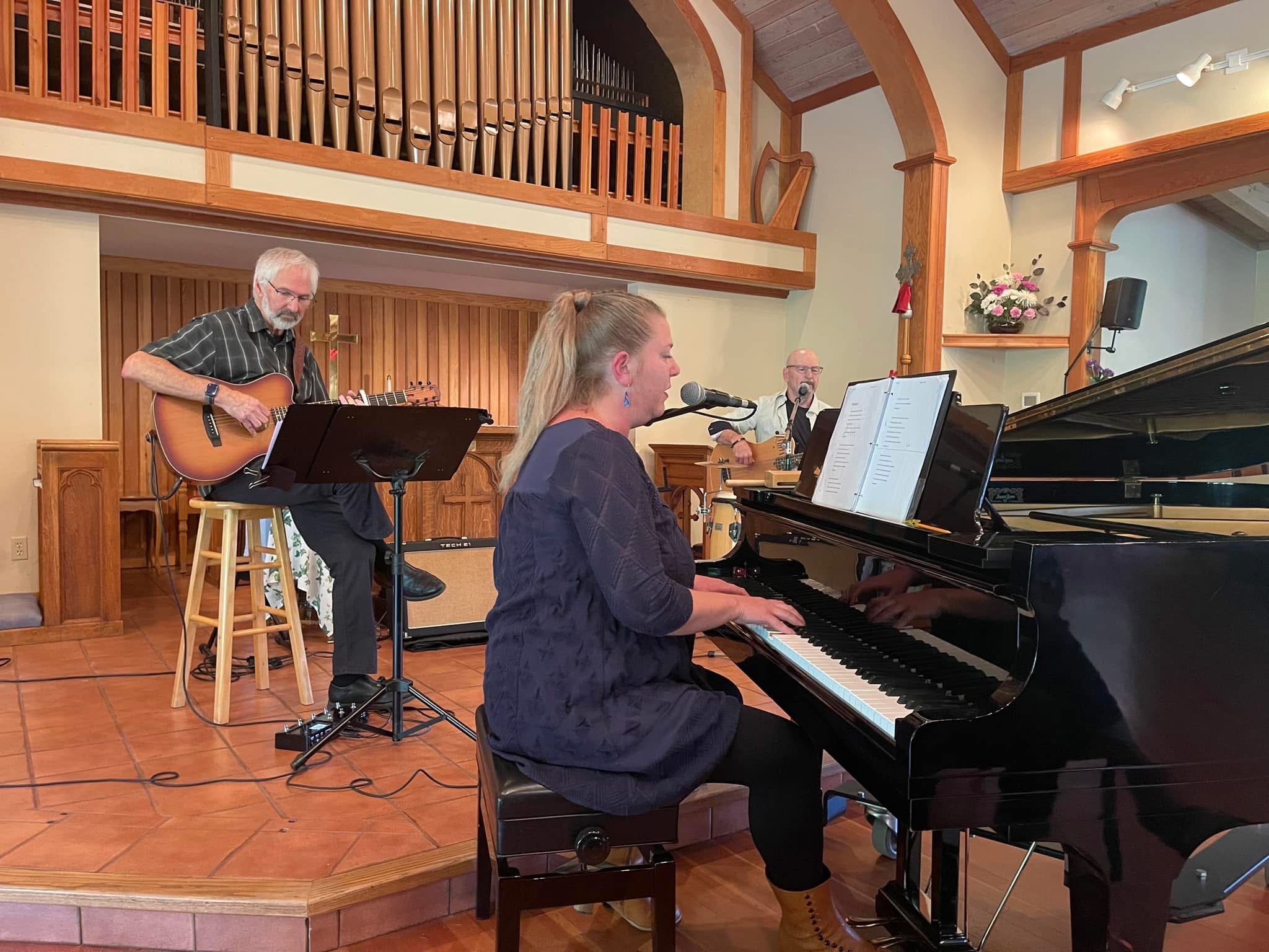 Suzanne Gay performing at grand piano in a chapel
